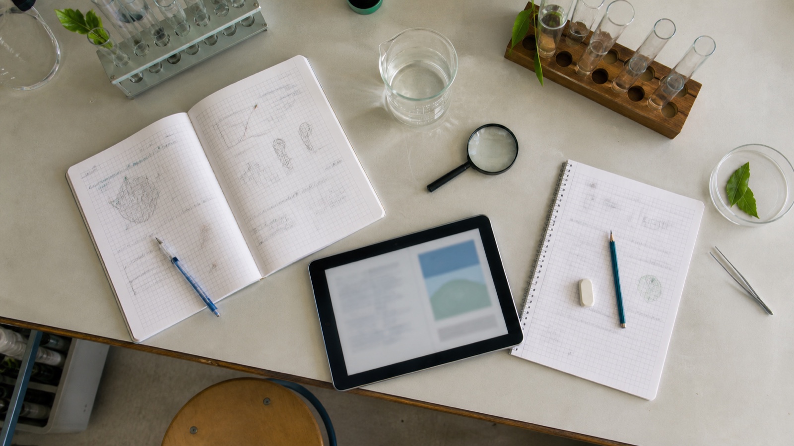 理科実験の道具とノートとタブレットを並べた学習机