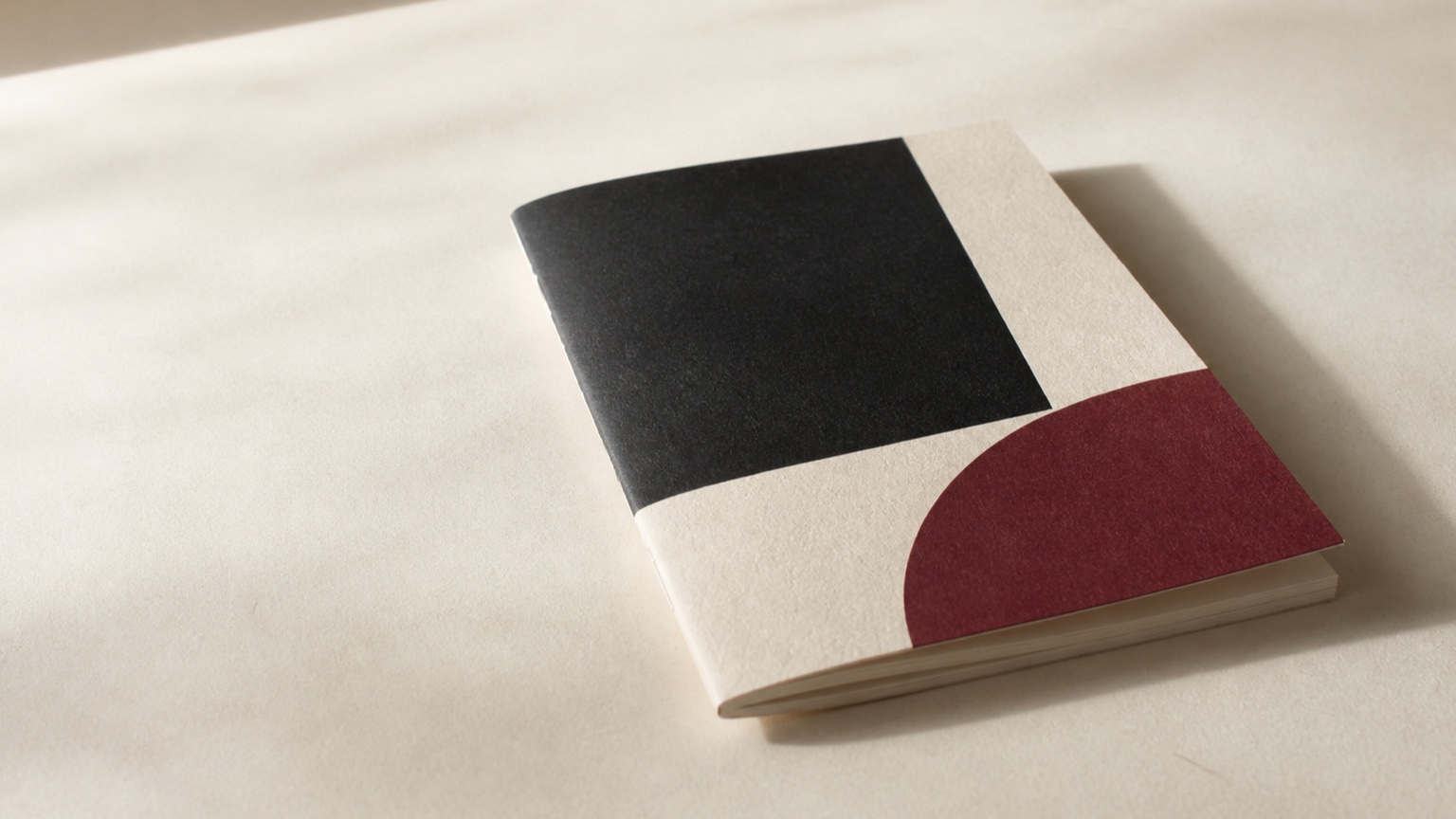 生成り地に黒とえんじの幾何学表紙の冊子